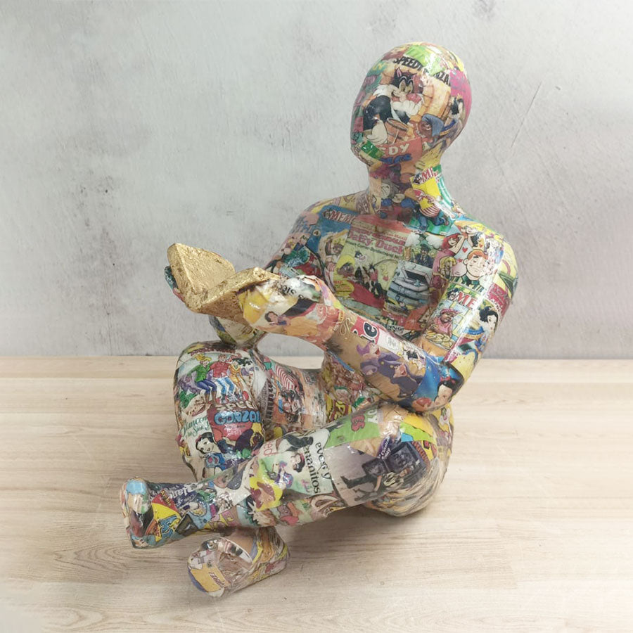 Adam sentado con libro forrado con historietas chico