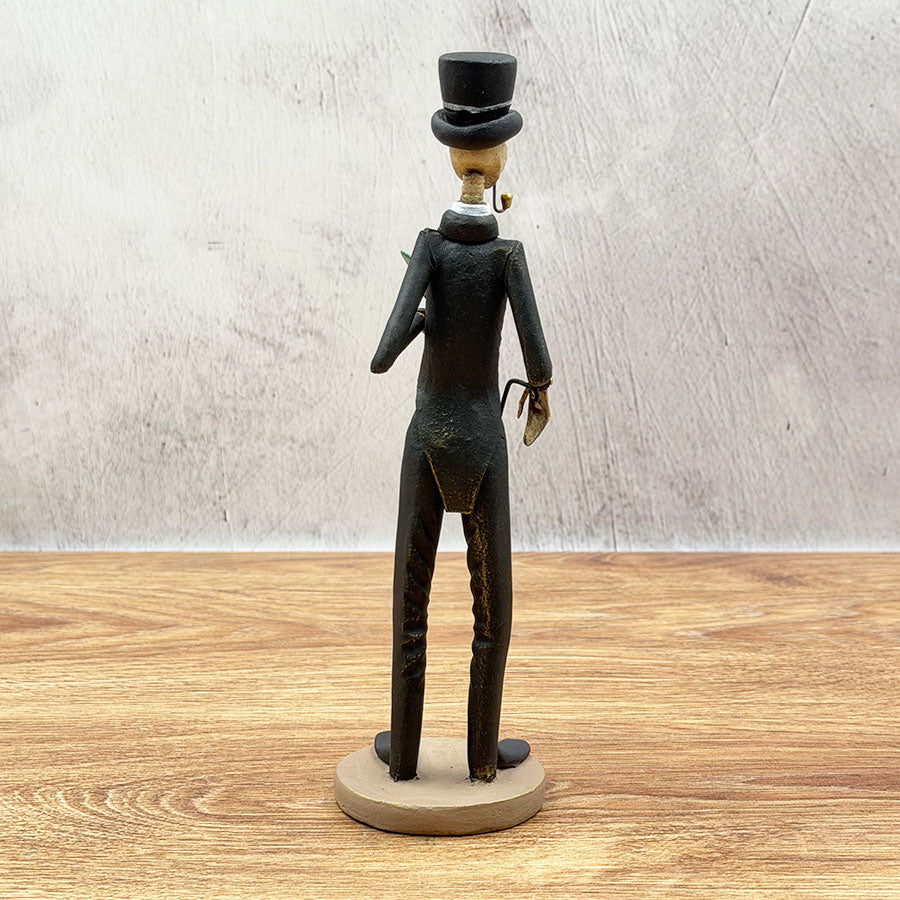 Catrín in a black suit with a cane