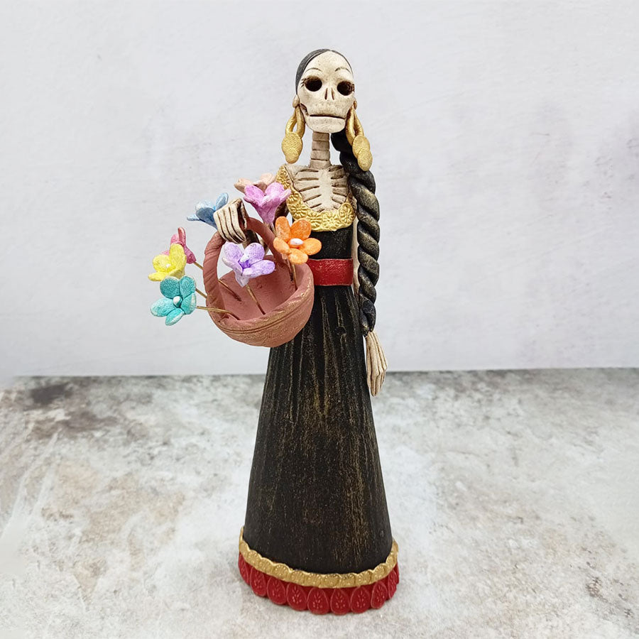 Catrina con vestido café y canasta de flores