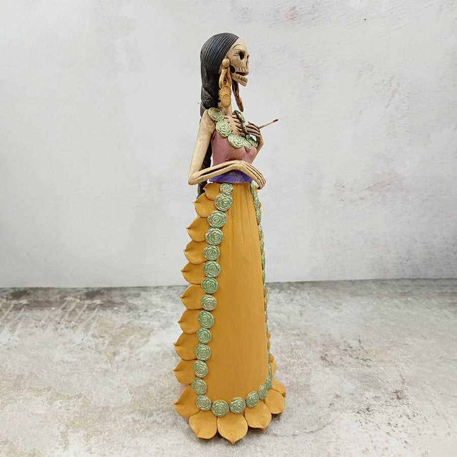 Catrina con vestido rosa y mandil amarillo