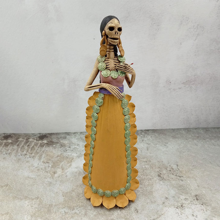 Catrina con vestido rosa y mandil amarillo