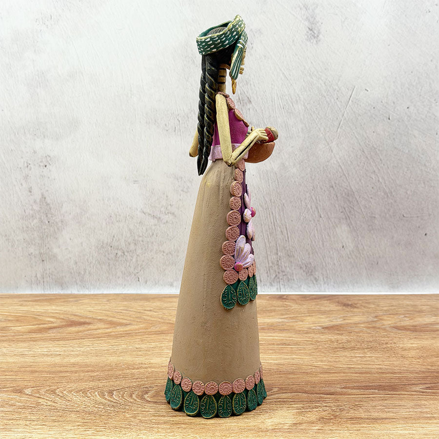 Catrina in a brown dress with a basket and shawl