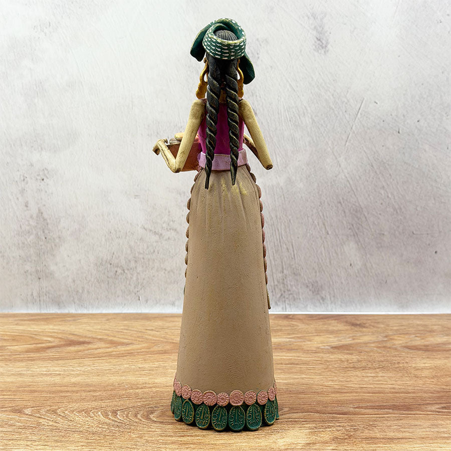 Catrina in a brown dress with a basket and shawl