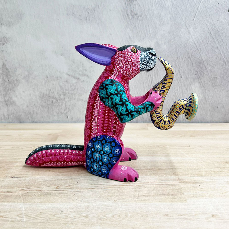 Conejo alebrije rosa con saxofón