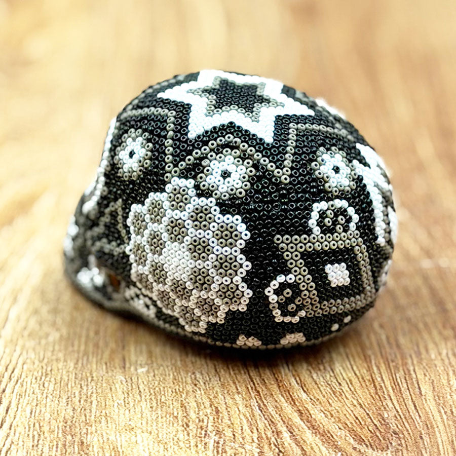 Black and white skull with Huichol art