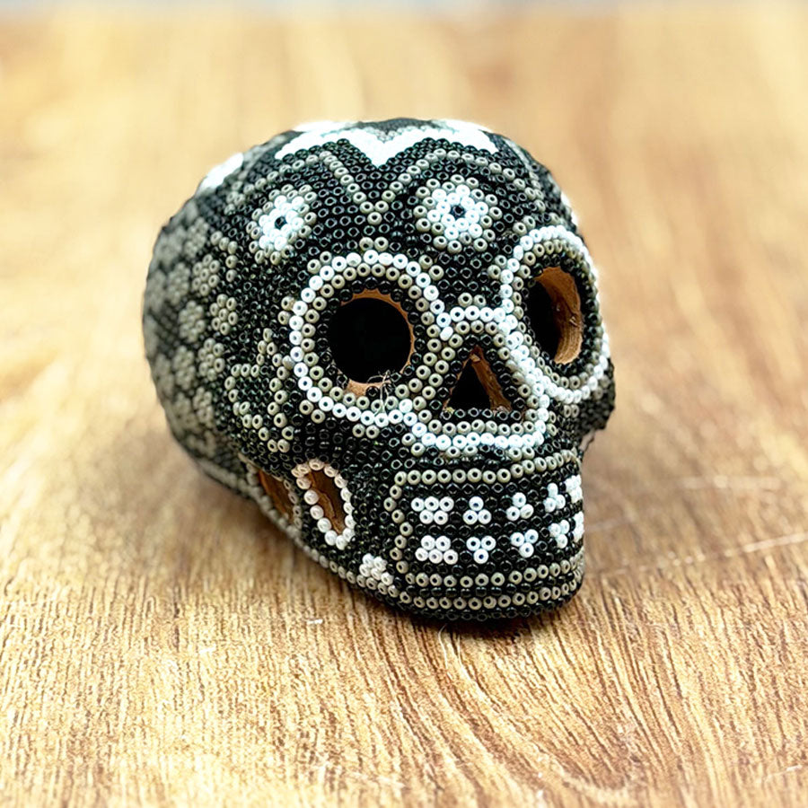 Black and white skull with Huichol art