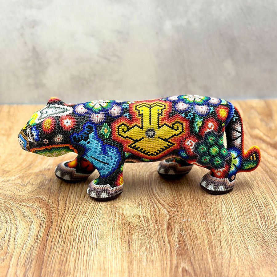 Jaguar caminando con diseño huichol multicolor