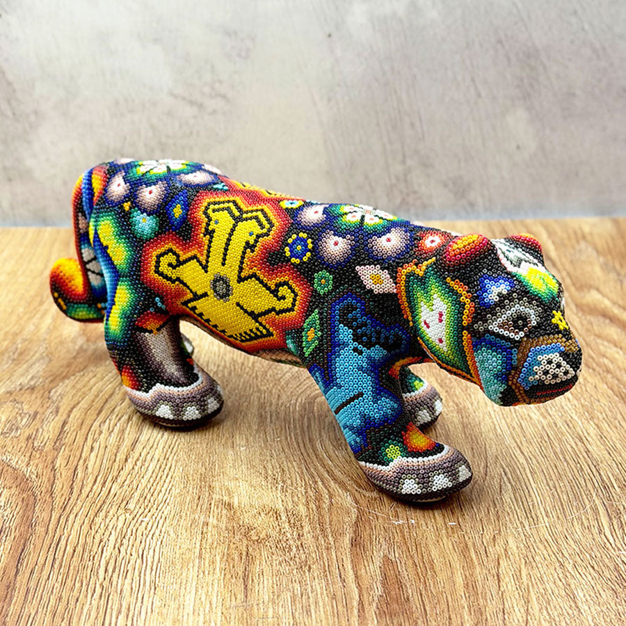 Jaguar caminando con diseño huichol multicolor