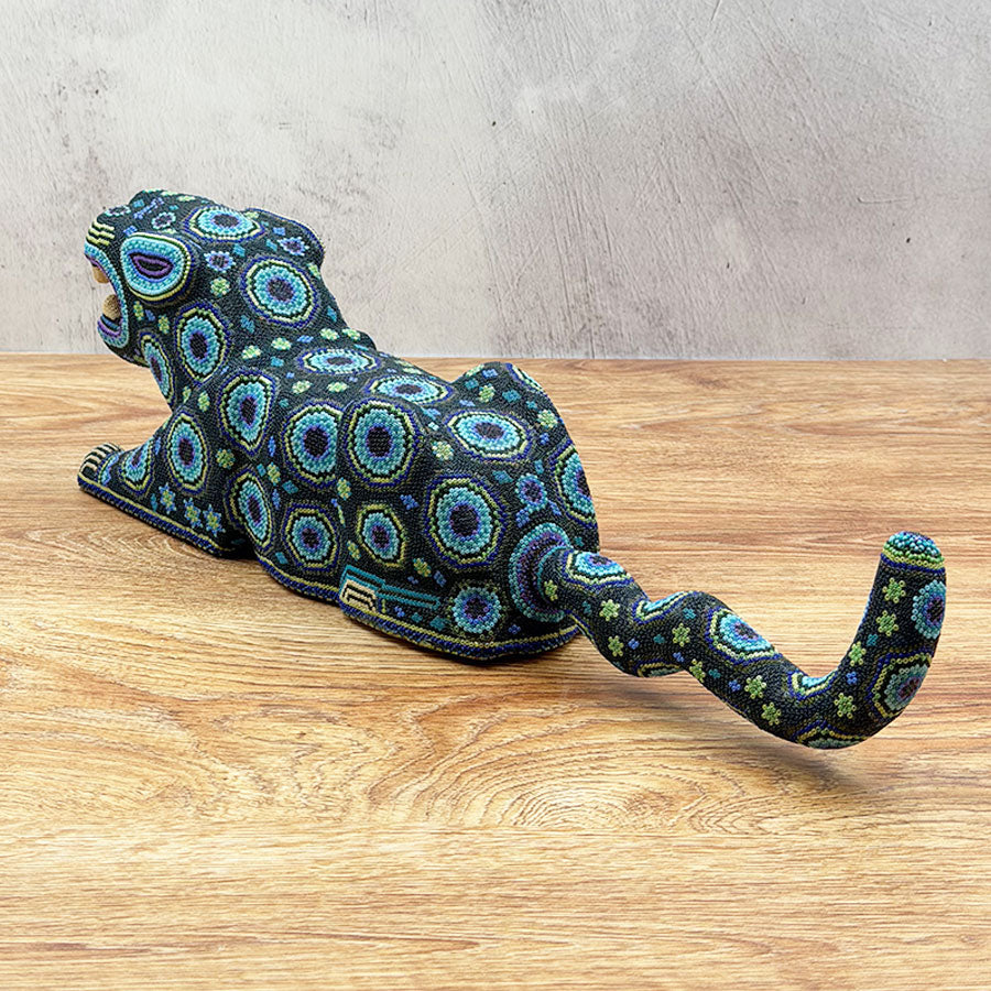Blue jaguar lying down with Huichol design