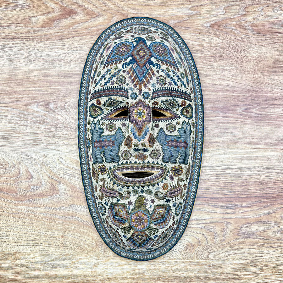 Máscara azul con águilas en diseño huichol