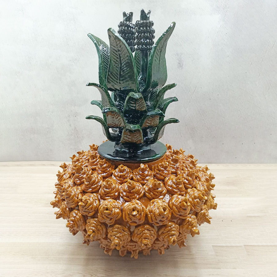 Yellow pineapple "pirinola" design with green lid made of glazed clay
