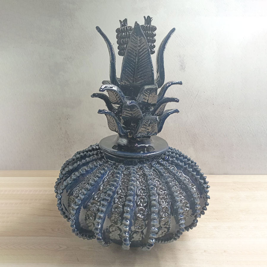 Navy blue pineapple with a spinning top design in glazed clay